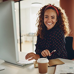 Woman smiling while sitting at desk in office