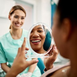 Patient smiling at reflection in treatment chair