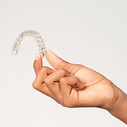 Closeup of teen holding clear aligner