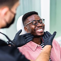 Dentist looking at smiling patient's teeth