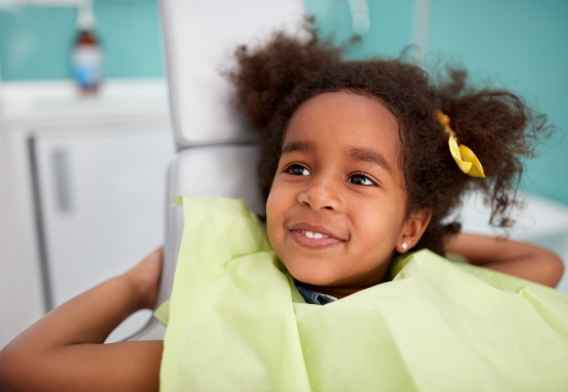 Girl smiling in pediatric dental chair