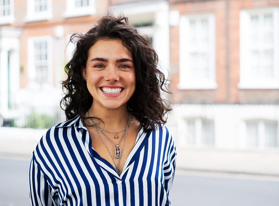 Portrait of happy, smiling woman standing outdoors