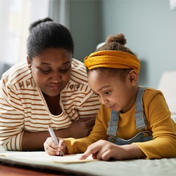 Child and parent drawing on bedroom floor