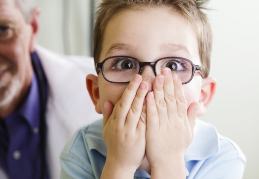 Child in need of emergency dentistry covering mouth