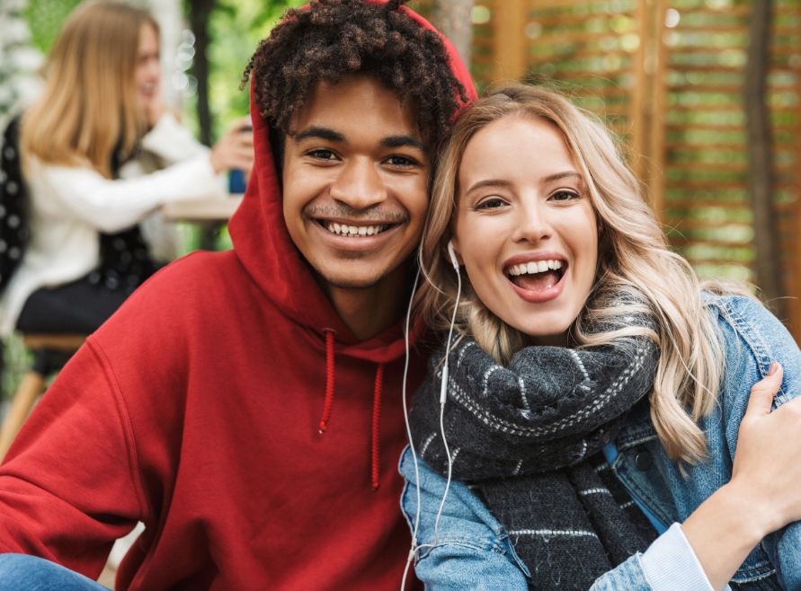 Young man and woman smiling after orthodontic treatment