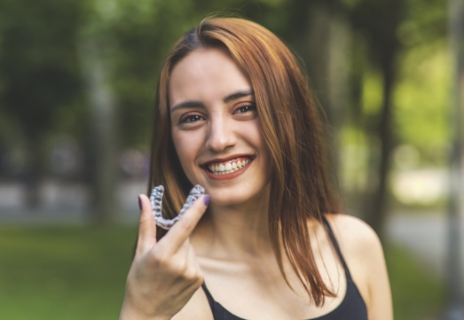 Young woman holding clear aligner