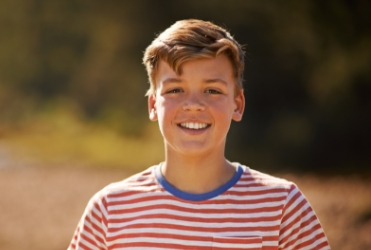 Young child smiling after emergency dentistry treatment