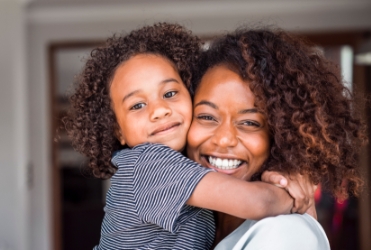 Mother holding happy child after sedation dentistry visit