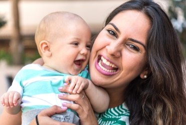 Mother holding baby after lip and Tongue-Tie treatment