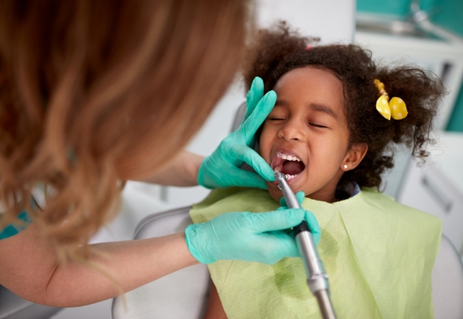 Child receiving dental checkup and teeth cleaning