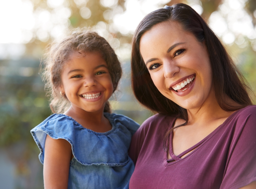 Mother and child smiling together after restorative dentistry