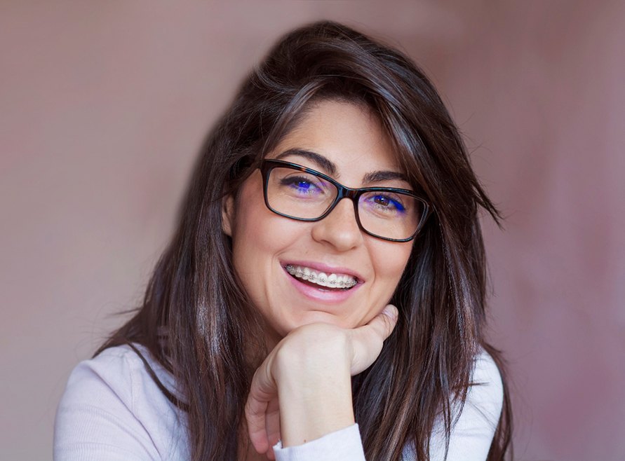 Woman with glasses and traditional braces smiling