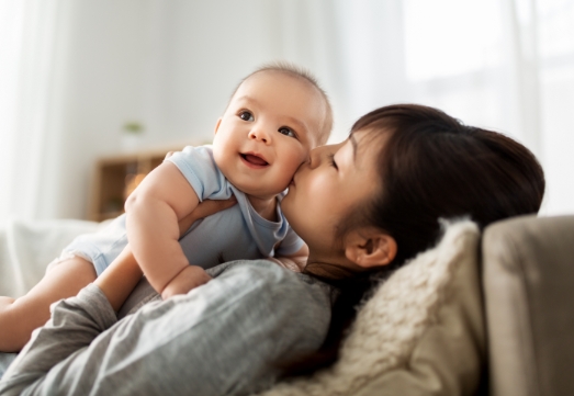 Mother and infant smiling together after visiting the dentist