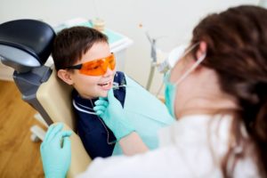 a pediatric dentist looking at a child's teeth